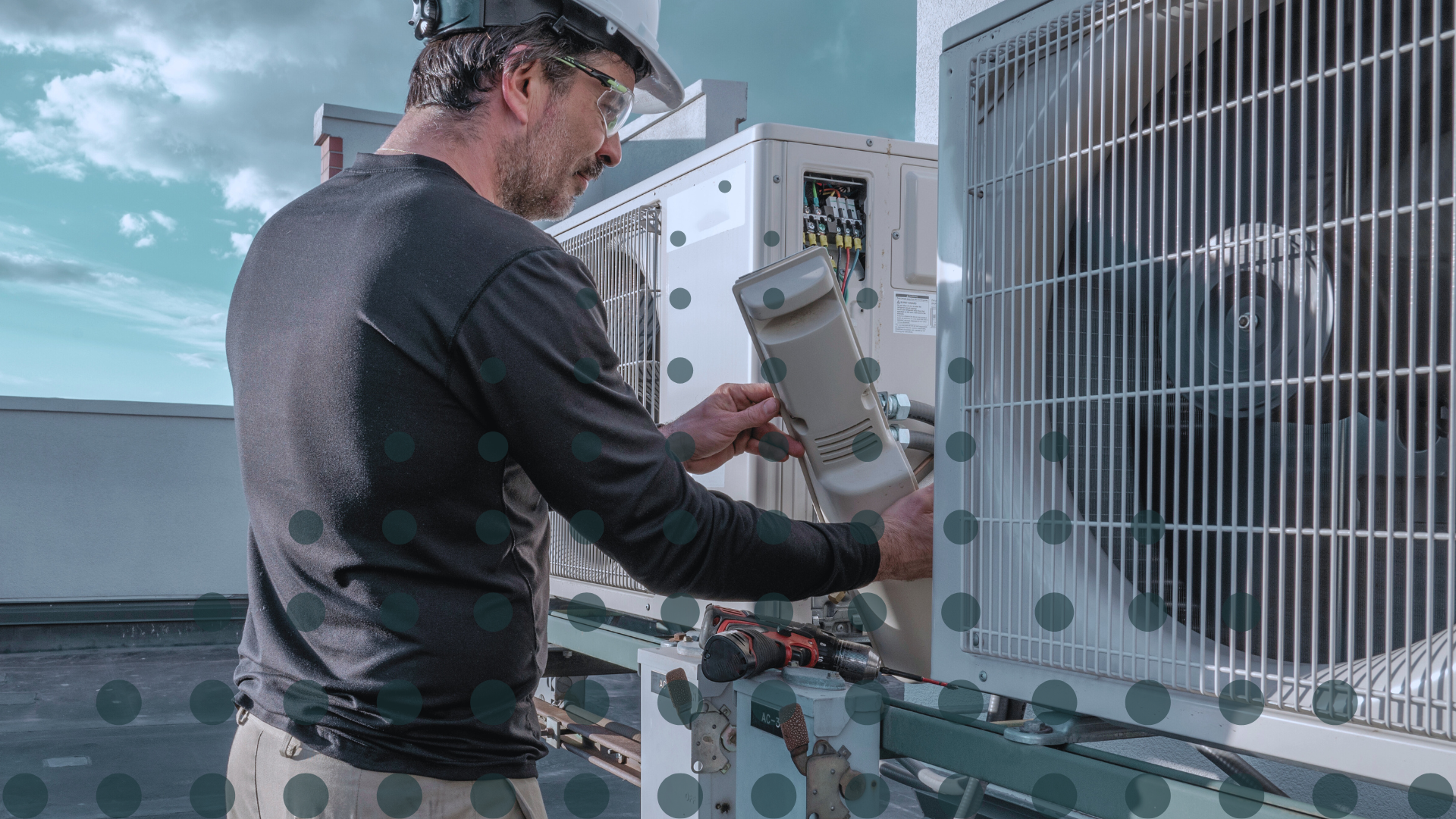 A tradesmen providing HVAC maintenance on a rooftop unit